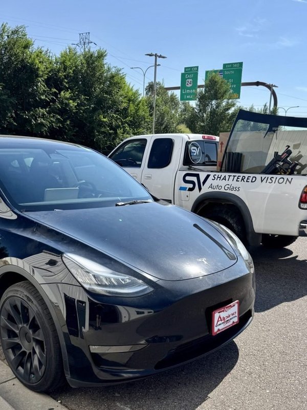 Black Tesla beside the Shattered Vision mobile van for windshield replacement and ADAS calibration in Colorado Springs