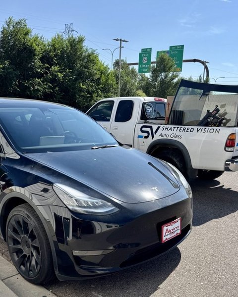 Black Tesla beside the Shattered Vision mobile van for windshield replacement and ADAS calibration in Colorado Springs