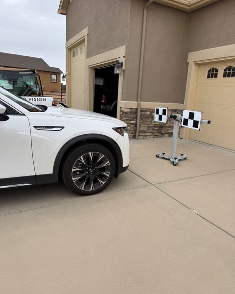 White SUV set up with ADAS calibration targets in a Colorado Springs driveway