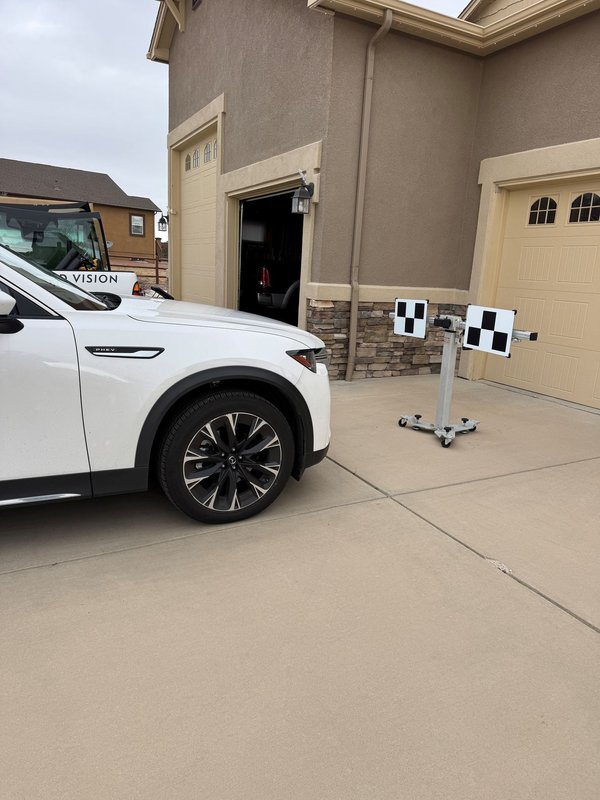 White SUV set up with ADAS calibration targets in a Colorado Springs driveway